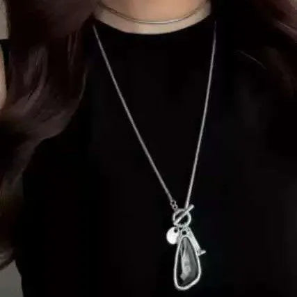 Long geometric alloy pendant necklace on a snake bones chain for sweaters.