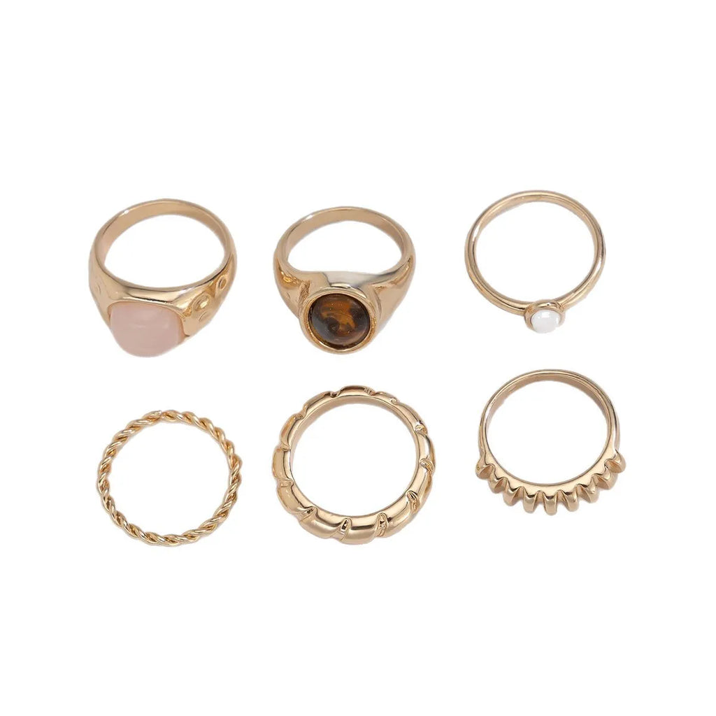 Six geometric alloy rings with light gold electroplating arranged as a set