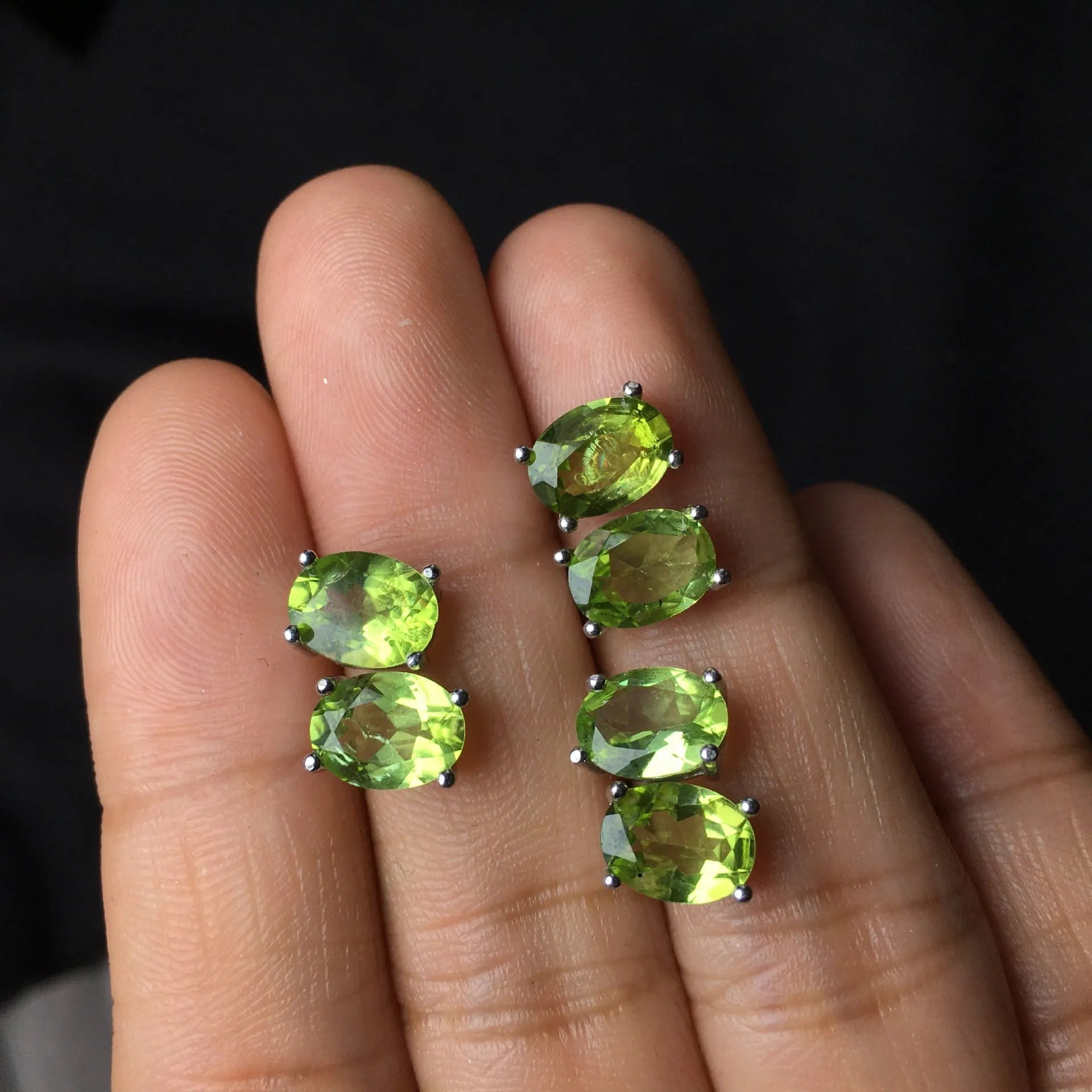 Close-up of natural grass green olivine stud earrings in S925 sterling silver settings.