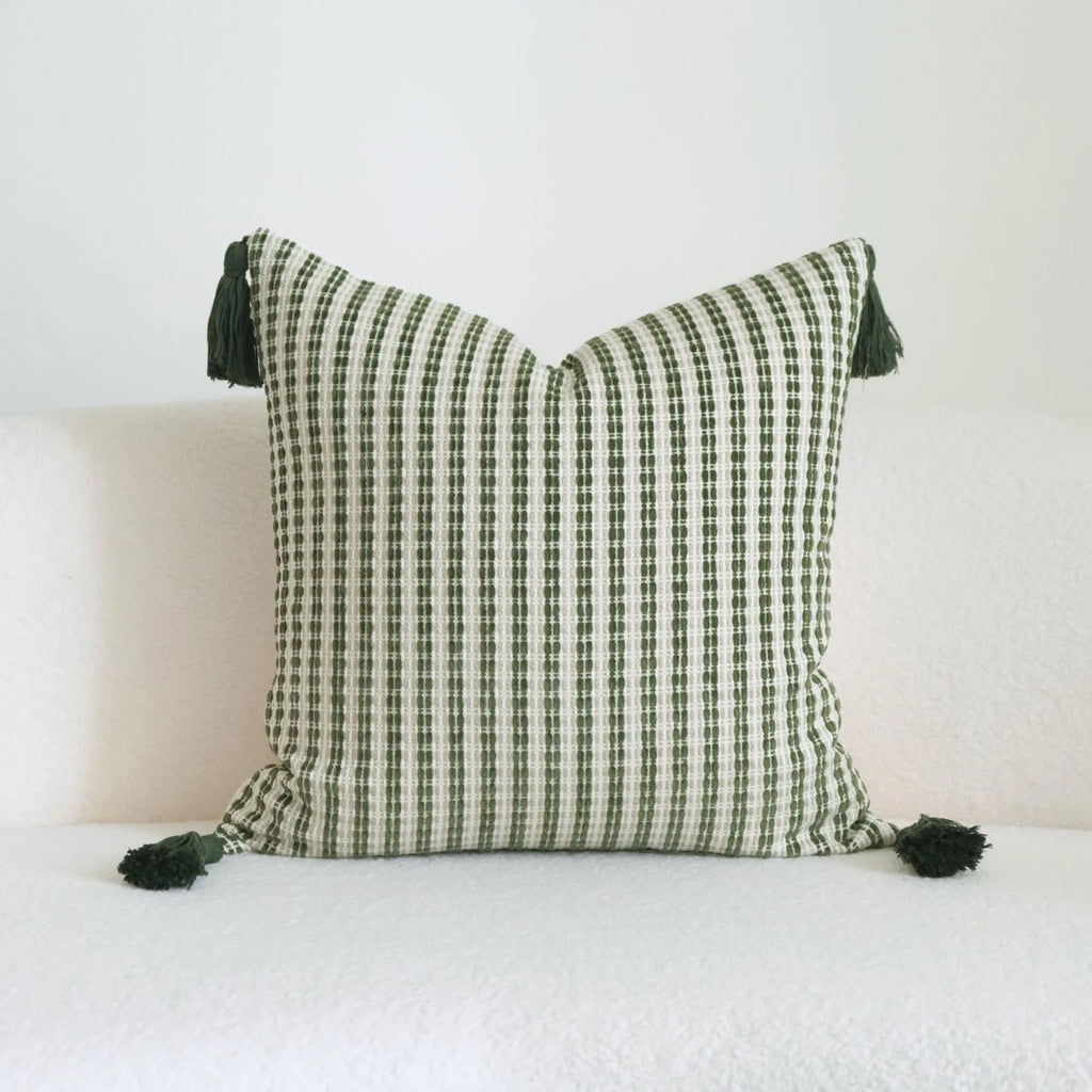 Green decorative pillow with botanical embroidery on cotton linen fabric, shown with tassel and bead details.