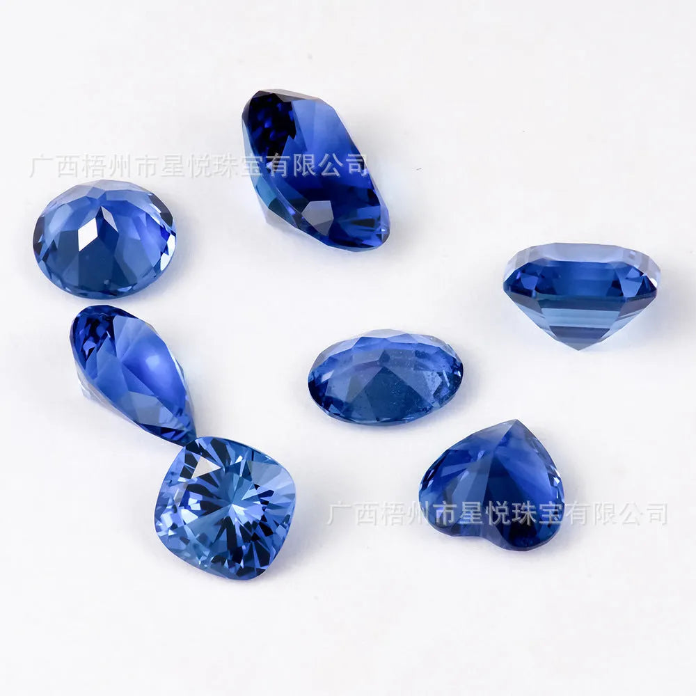 Royal blue love-shaped tiara cultivation gemstone in heart, round, and pear shapes on a jeweller's cloth.