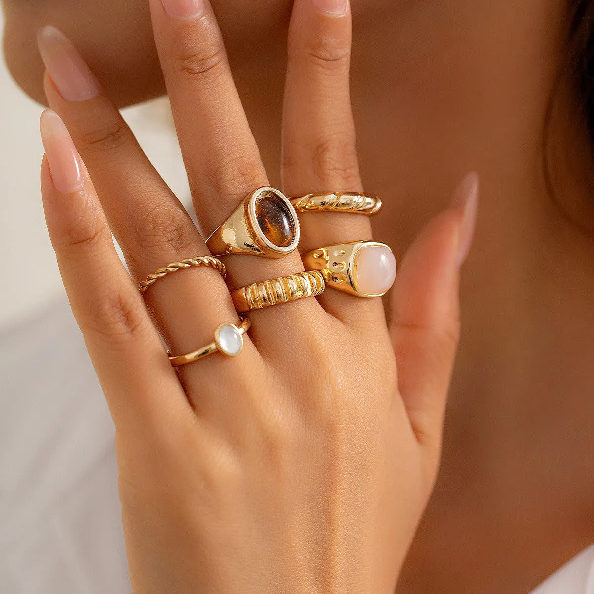 Six geometric alloy rings with light gold electroplating arranged as a set