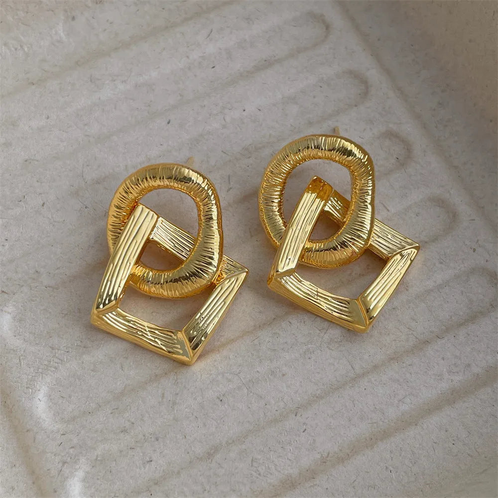 Retro style geometric circle pendant earrings in gold or silver colour with a 3.4cm drop length.