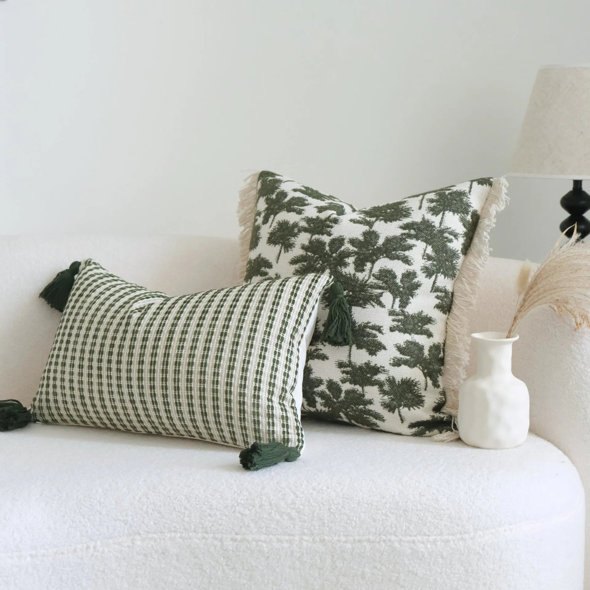 Green decorative pillow with botanical embroidery on cotton linen fabric, shown with tassel and bead details.