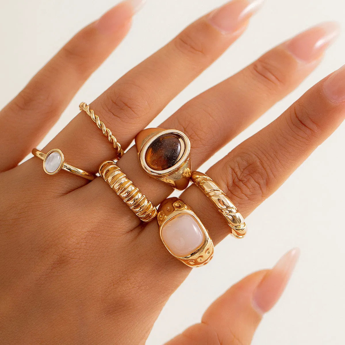 Six geometric alloy rings with light gold electroplating arranged as a set