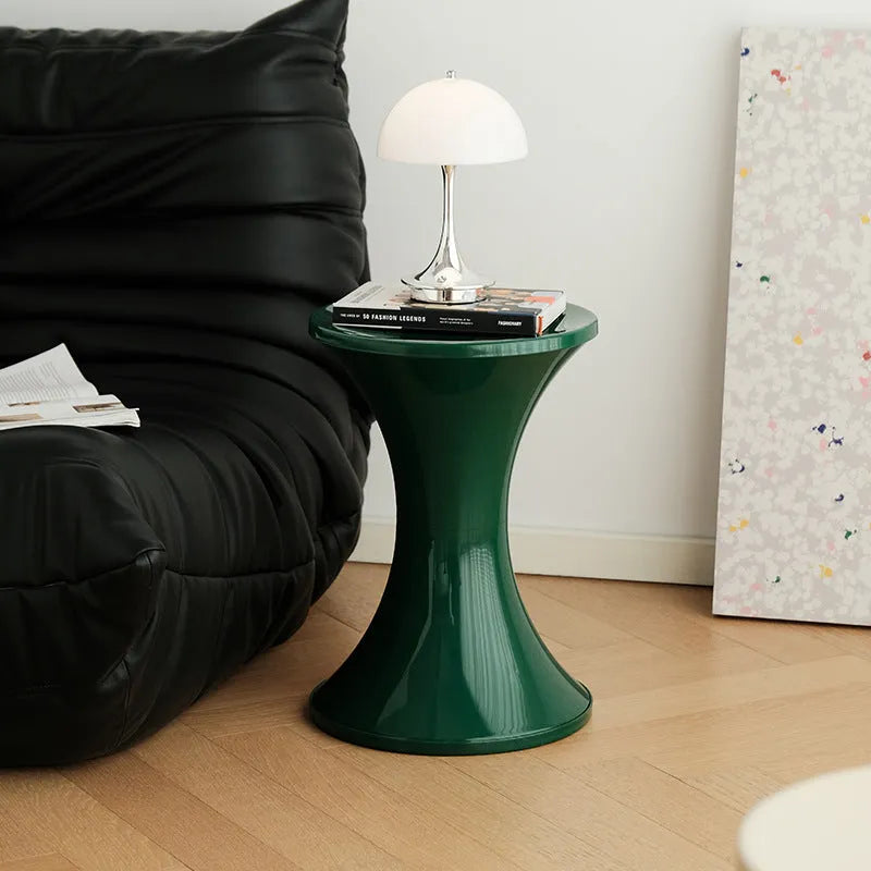 A plastic hourglass-style shoe changing stool in one of five available colours: black, green, red, white, or brown.
