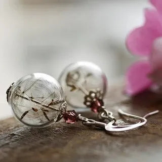 Transparent glass ball earrings with dandelion seed design inside, shown with French hooks
