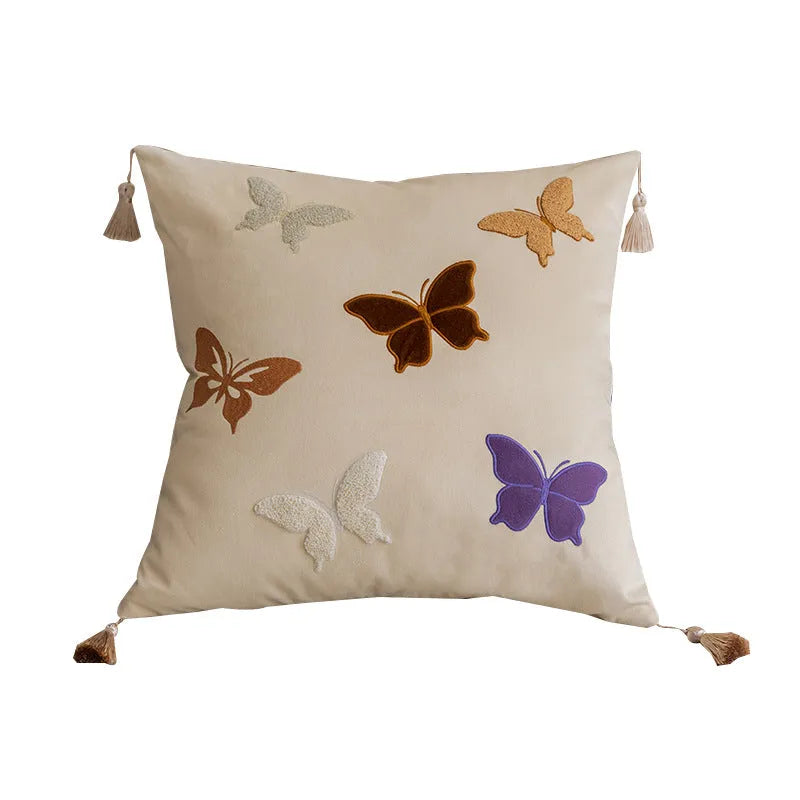 Square beige couch pillow with detailed Chinese-style butterfly embroidery.