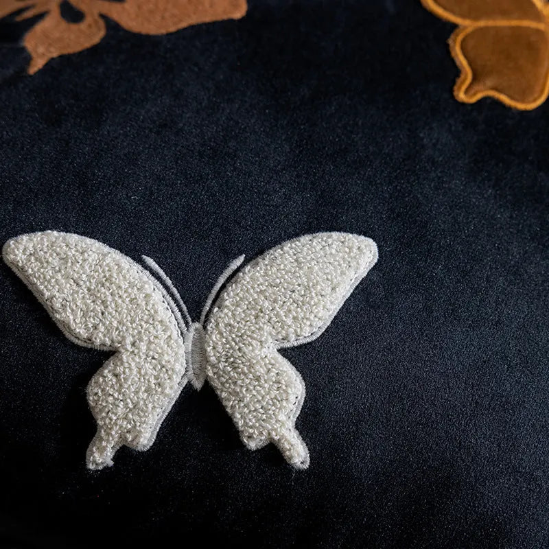 Square beige couch pillow with detailed Chinese-style butterfly embroidery.