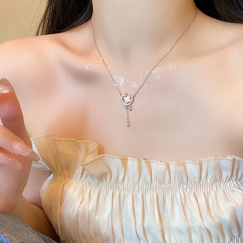 Gold star and moon pendant necklace on a model, showing adjustable clavicle chain.