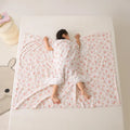 Anti-kick summer blanket in a choice of colours and sizes on a bed.
