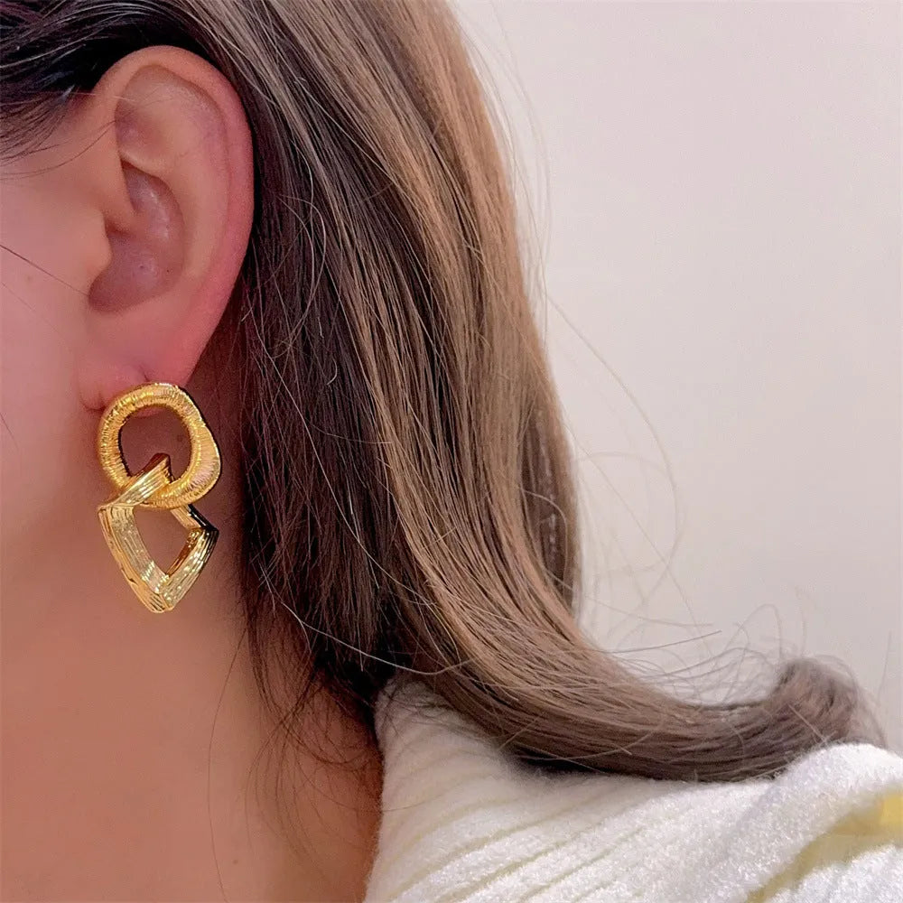 Retro style geometric circle pendant earrings in gold or silver colour with a 3.4cm drop length.