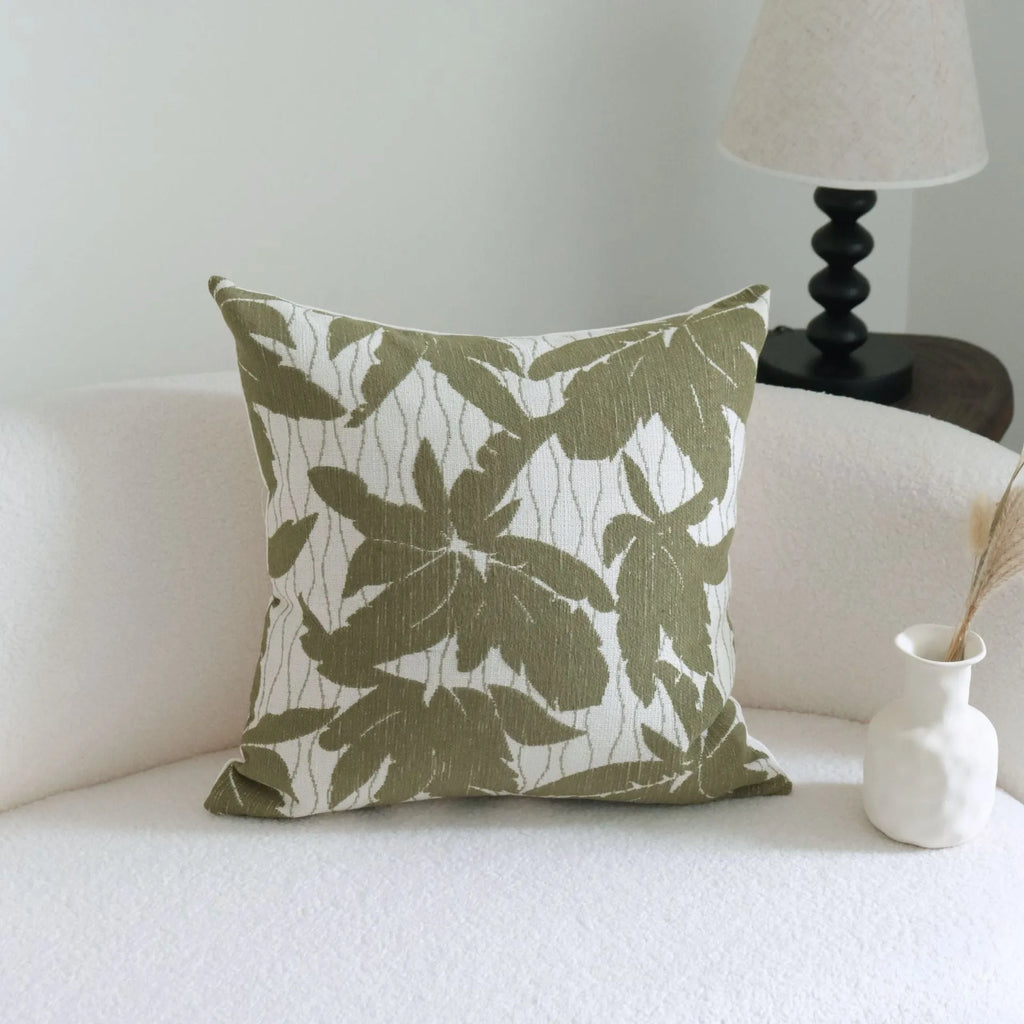 Green decorative pillow with botanical embroidery on cotton linen fabric, shown with tassel and bead details.