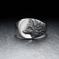 Geometric silver alloy wolf head signet ring for men on a grey background.