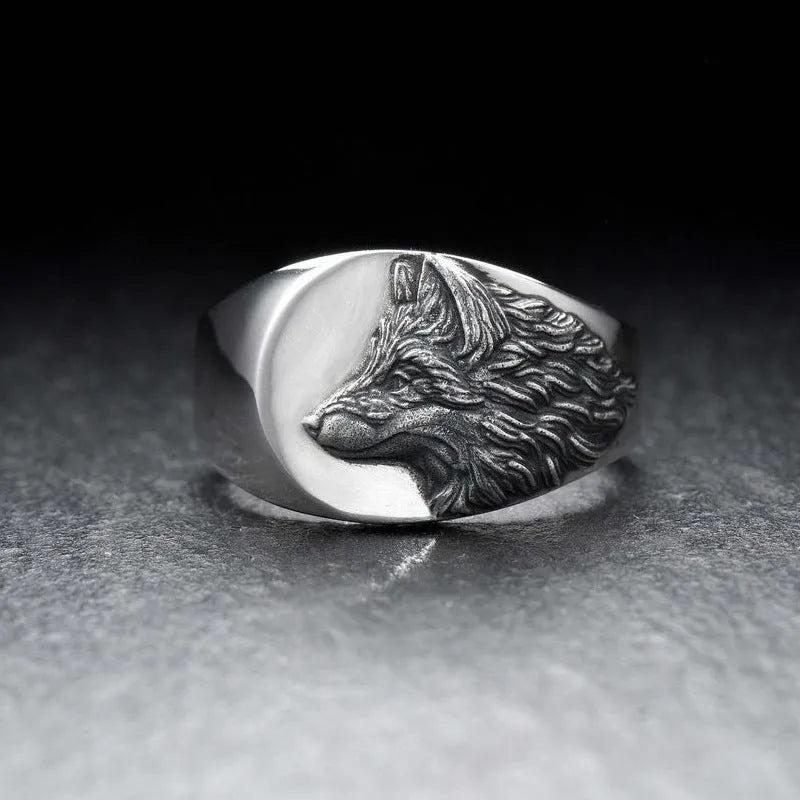 Geometric silver alloy wolf head signet ring for men on a grey background.