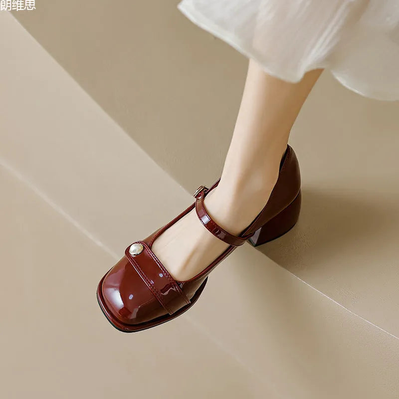 Women's patent leather chunky heel pumps with square toe and buckle fastening, shown in apricot colour.