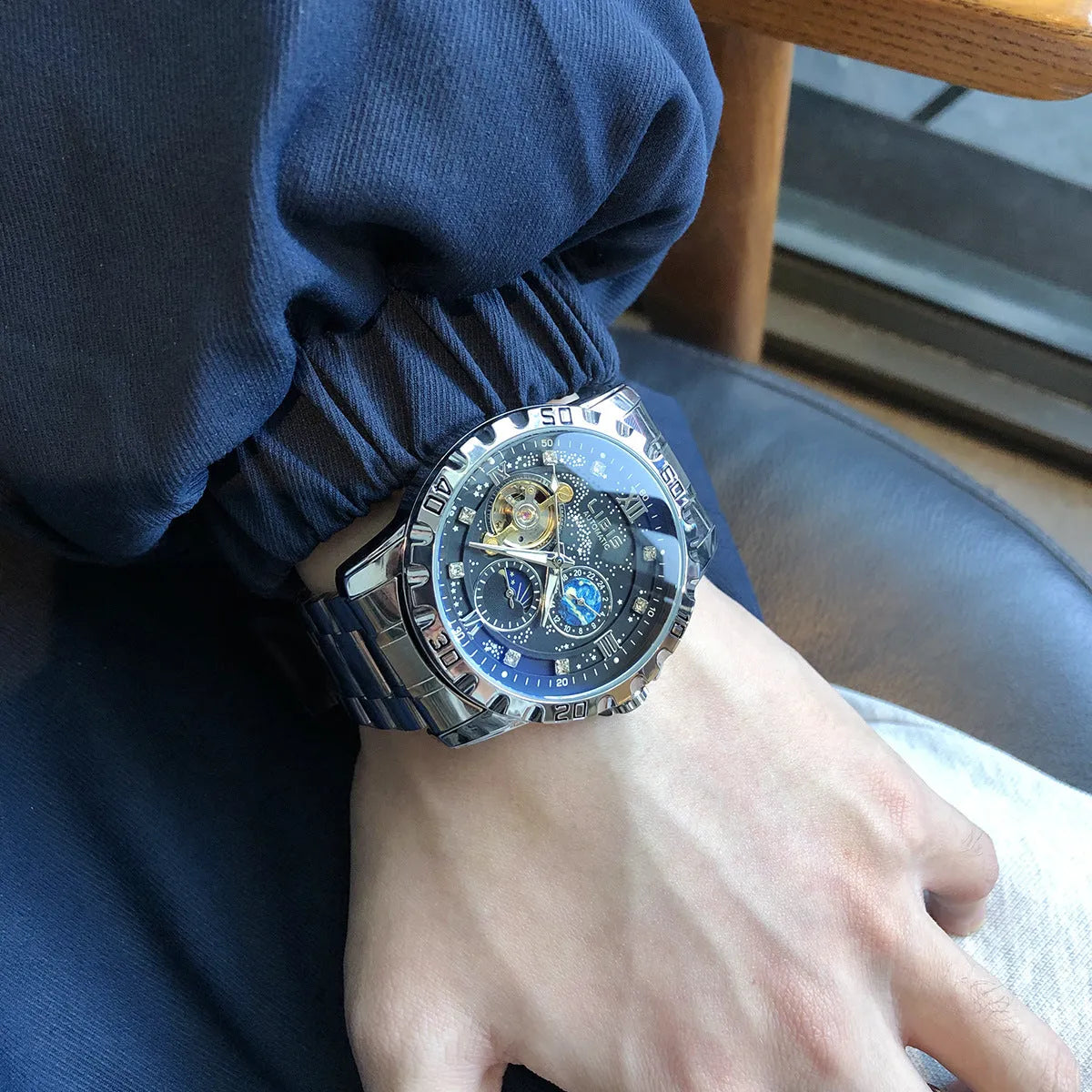 Men's silver automatic mechanical watch with starry dial, black genuine leather strap, and transparent case back showing movement
