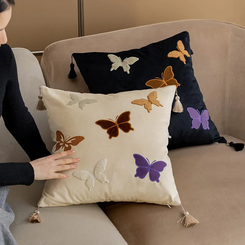 Square beige couch pillow with detailed Chinese-style butterfly embroidery.
