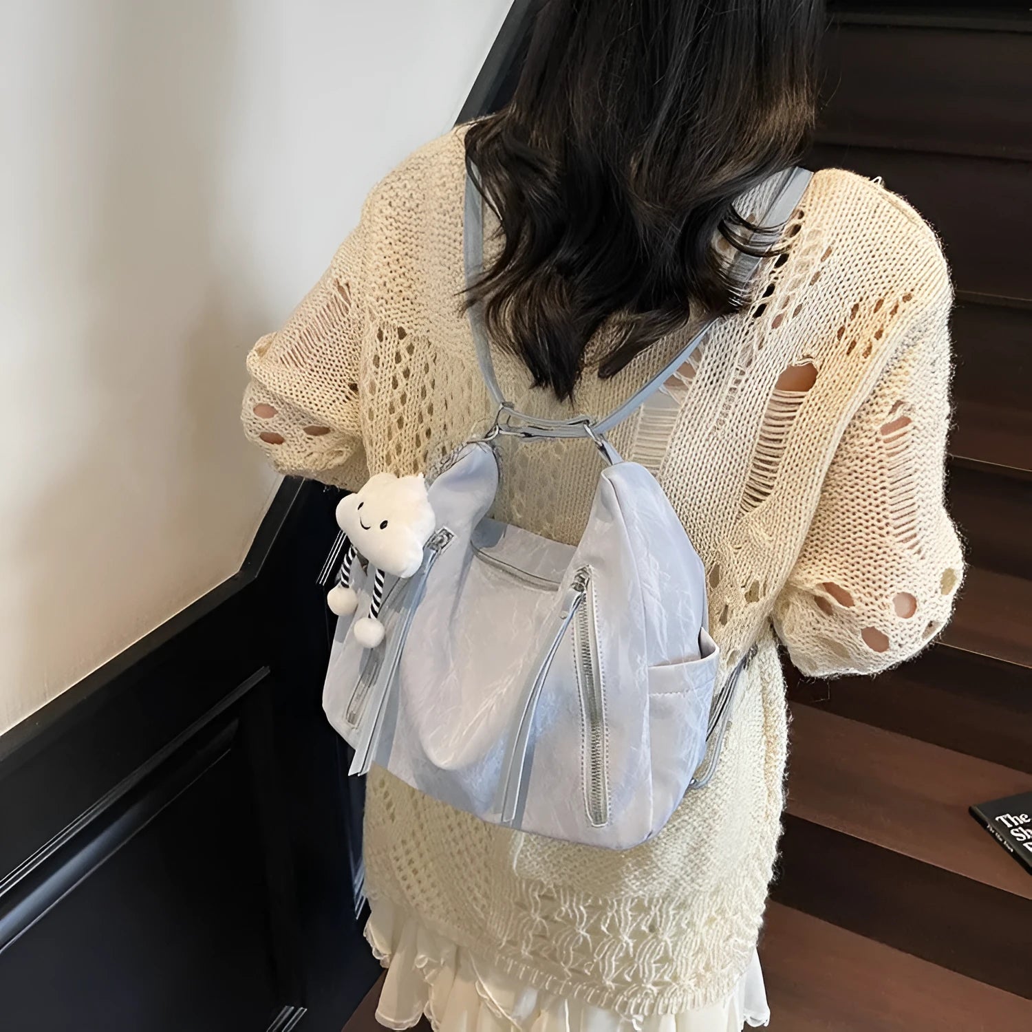 Women's fashion backpack in soft PU leather, shown in black, milky white, silver, and blue colour options with a pendant.