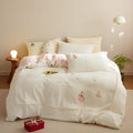 Winter milk fibre four-piece bedding set with green or pink Christmas tree pattern on a bed