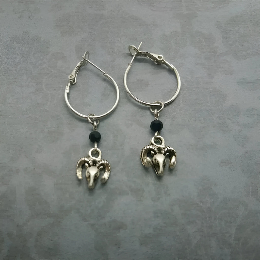 Silver-coloured alloy round earrings with a raised Tibetan antelope design.