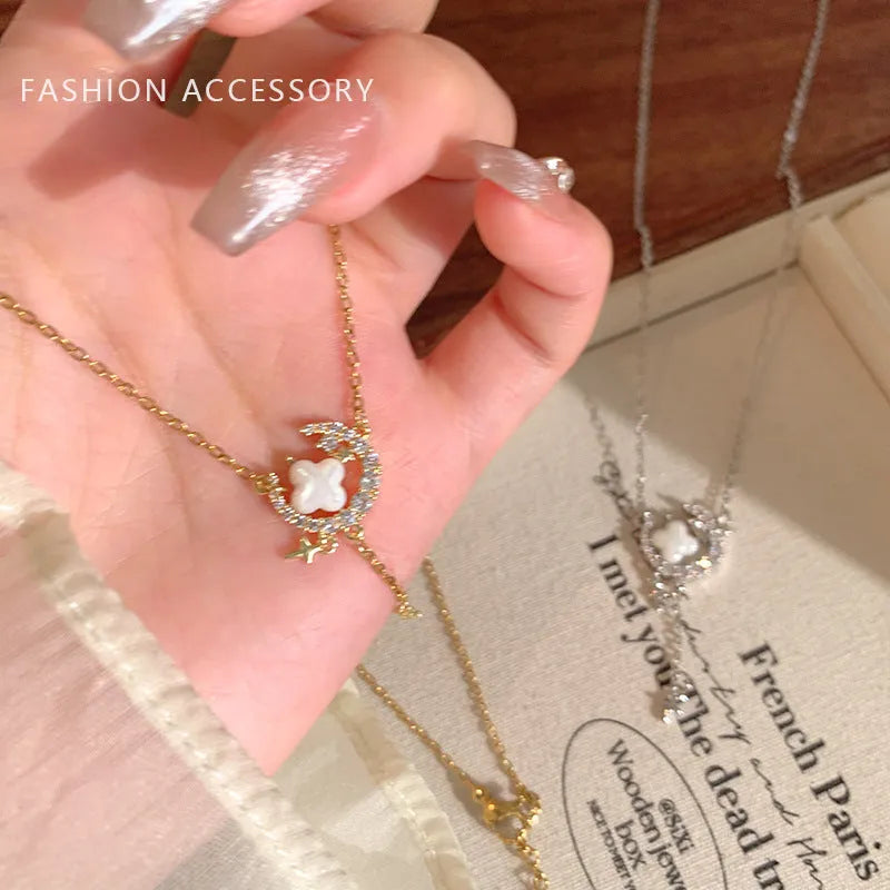 Gold star and moon pendant necklace on a model, showing adjustable clavicle chain.
