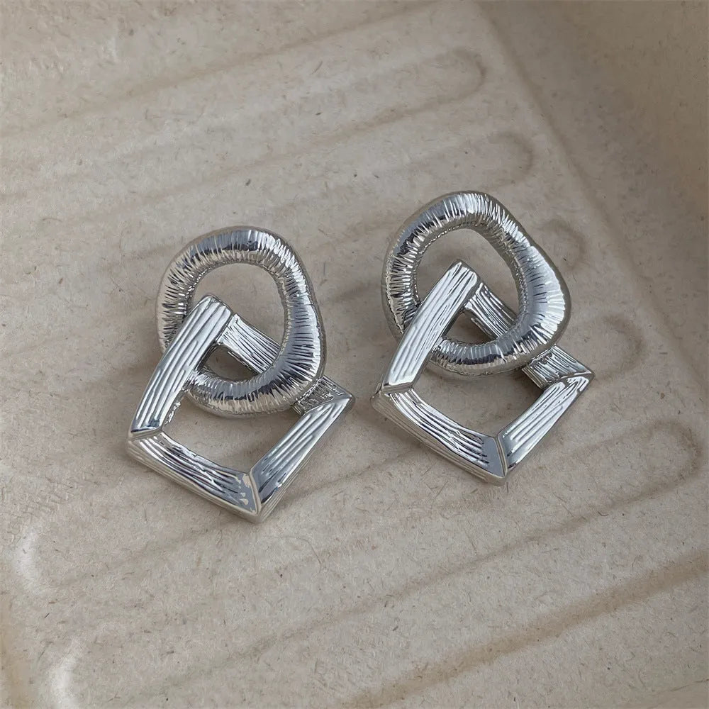 Retro style geometric circle pendant earrings in gold or silver colour with a 3.4cm drop length.