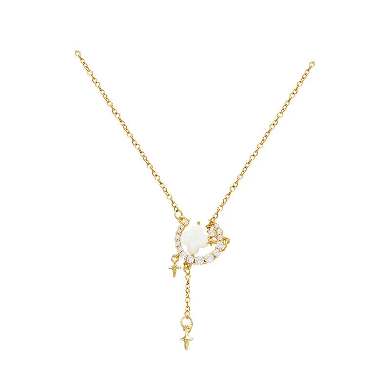 Gold star and moon pendant necklace on a model, showing adjustable clavicle chain.