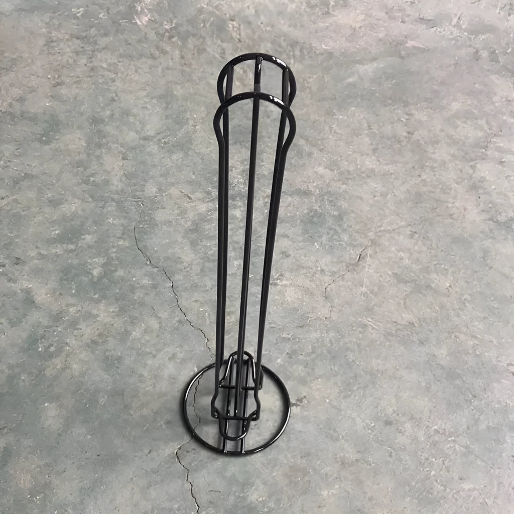 Black wrought iron coffee capsule storage rack holding pods on display shelves.