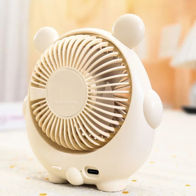 Cute puppy-themed USB desktop electric fan in various colours on a desk.