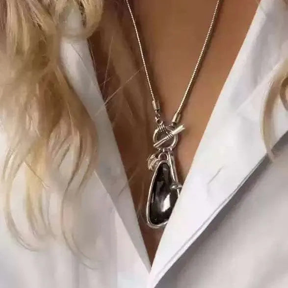 Long geometric alloy pendant necklace on a snake bones chain for sweaters.