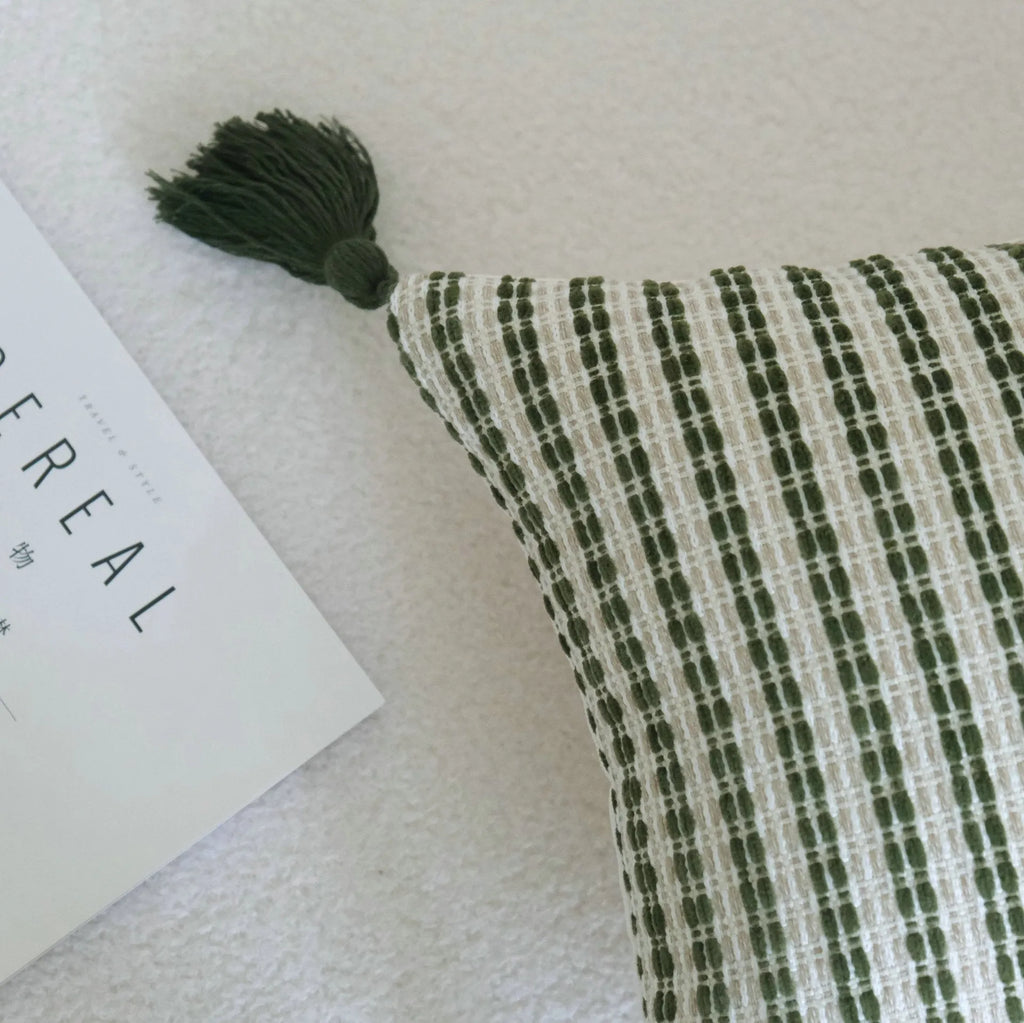 Green decorative pillow with botanical embroidery on cotton linen fabric, shown with tassel and bead details.