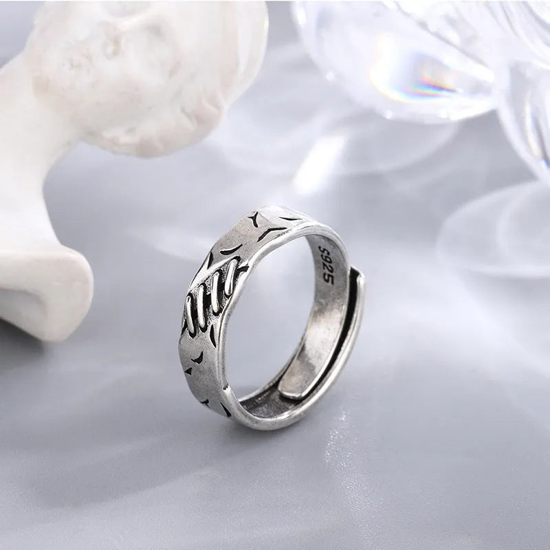 Black geometric copper ring with adjustable opening featuring round and oval design elements