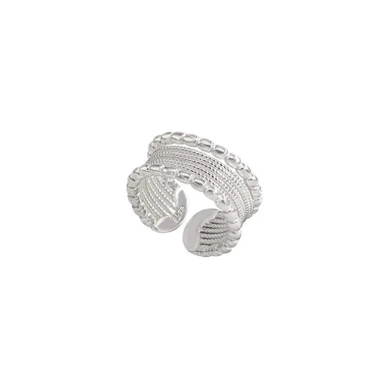 Copper-toned geometric alloy ring with a woven twisted design and adjustable opening.