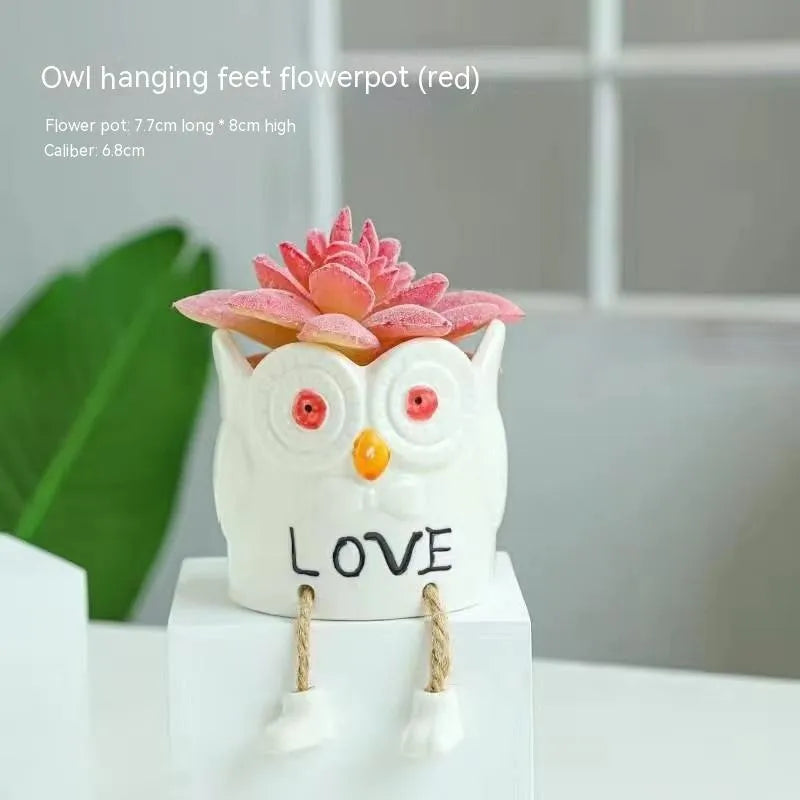 Ceramic cartoon-style hanging foot flowerpot for succulent plants on a desktop.