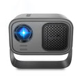 Black portable smart projector with remote control and cables on desk