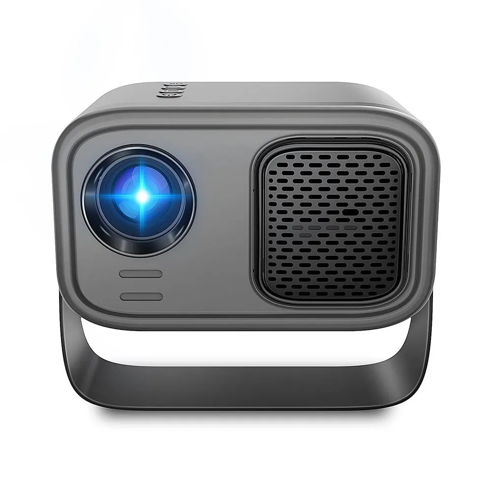 Black portable smart projector with remote control and cables on desk