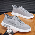 Grey men's low-top canvas casual shoes with a round toe and white rubber sole on a plain background.