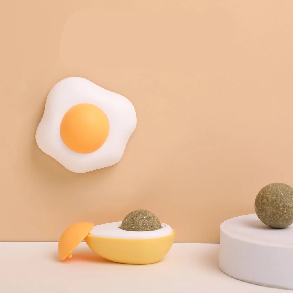 Interactive catnip ball toy with adhesive backing for walls, available in fried egg and poached egg designs