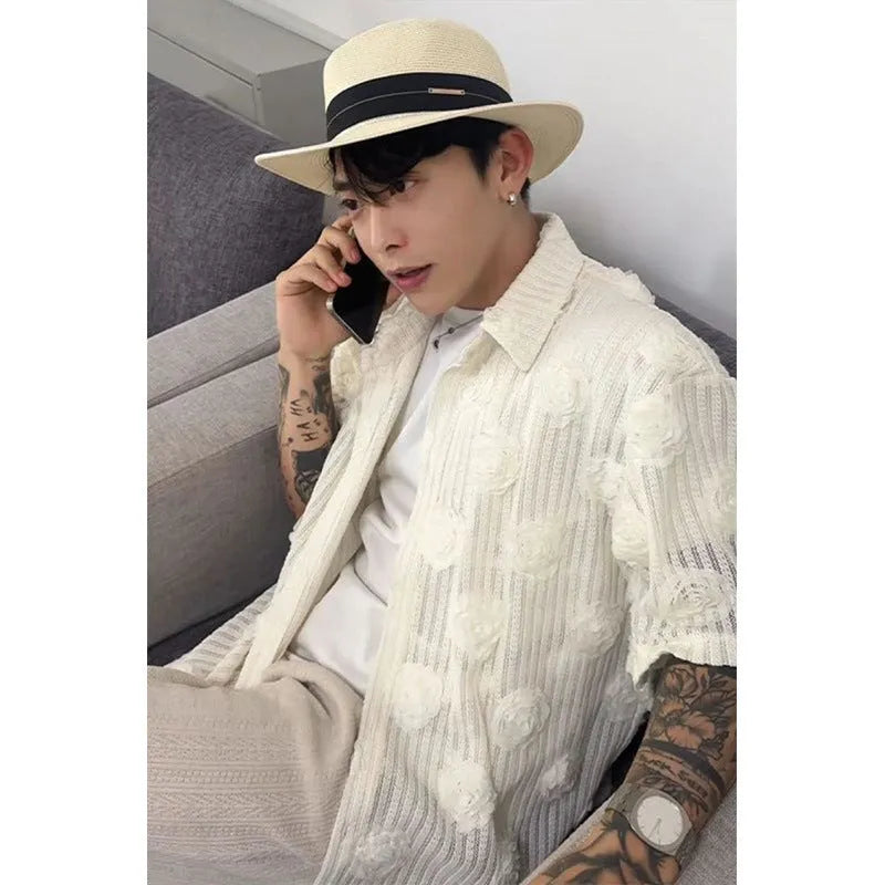 Man wearing a beige loose-fit short sleeve shirt with a textured three-dimensional floral print pattern.