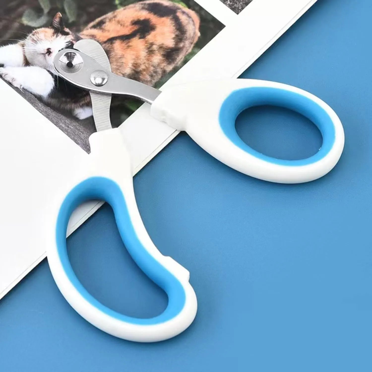 Blue pet nail clippers with a circular safety hole and cushioned non-slip handle.