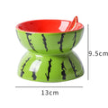 Orange patterned ceramic elevated cat bowl on a wooden floor.