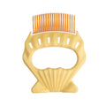 Green shell-shaped pet slicker brush with bent wire bristles and anti-slip handle on a white background.