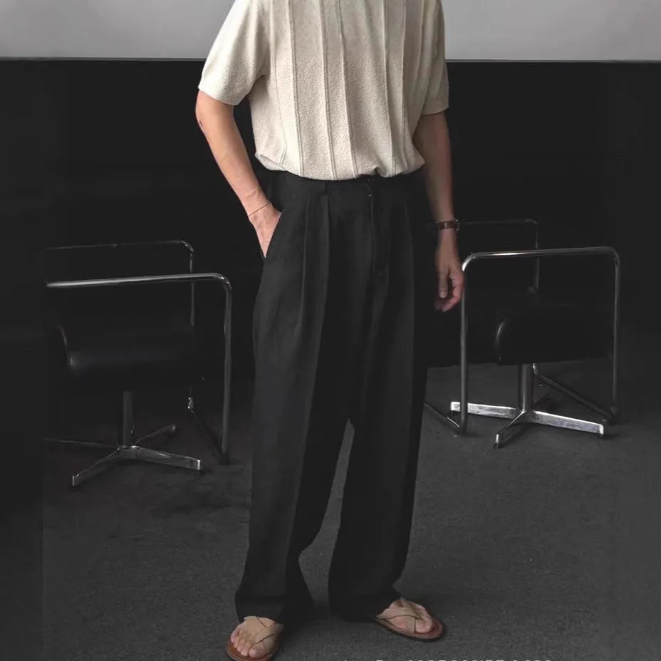 Men's apricot coloured loose-fit cotton linen blend trousers on a hanger, showing zip fly and mid-waist design.
