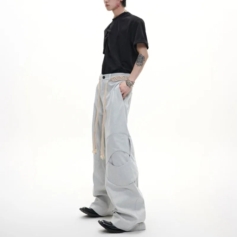 Men's dark blue loose fit straight-leg jeans with decorative belt stitching and zipper details.