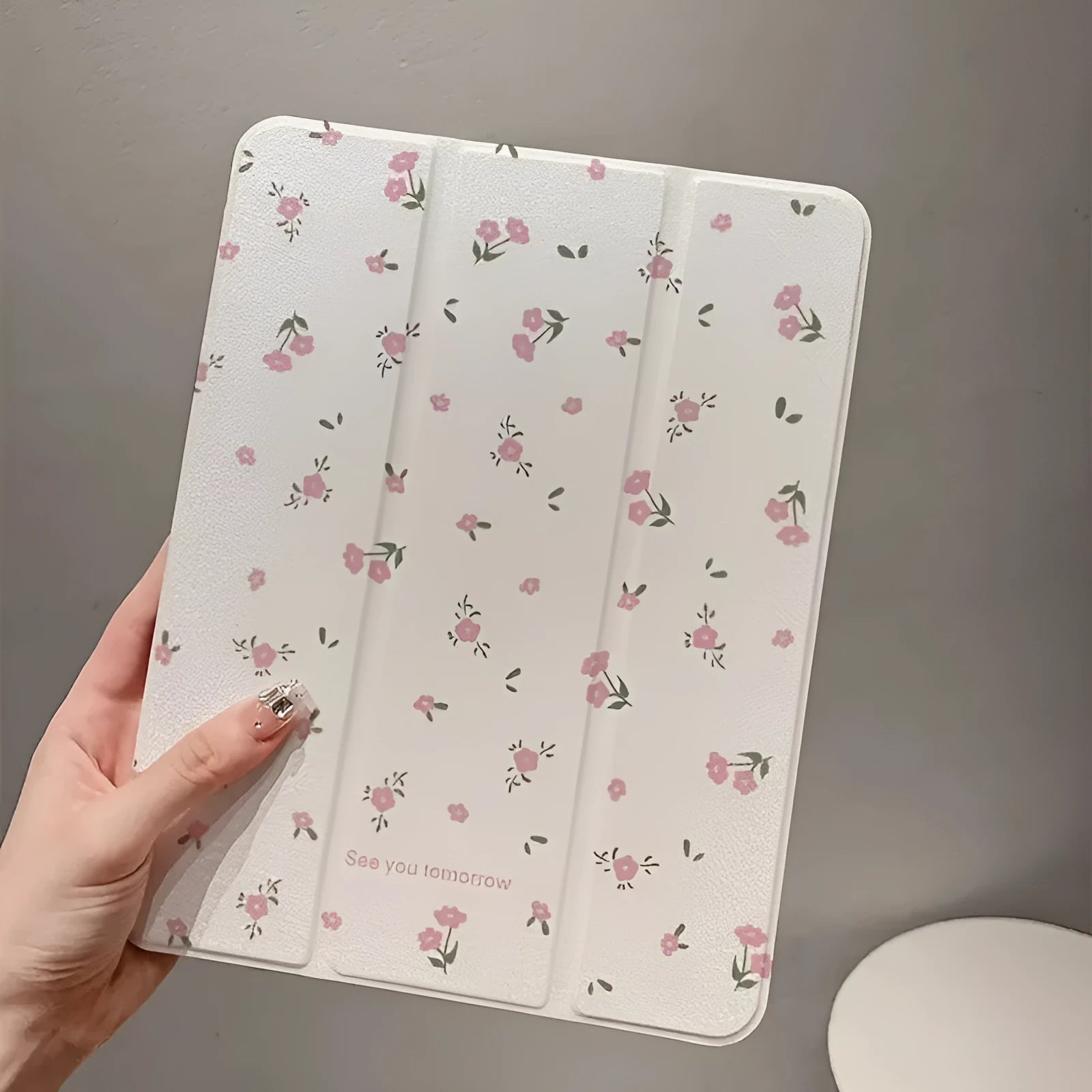 Transparent floral tri-fold tablet case for iPad showing magnetic closure and decorative pattern