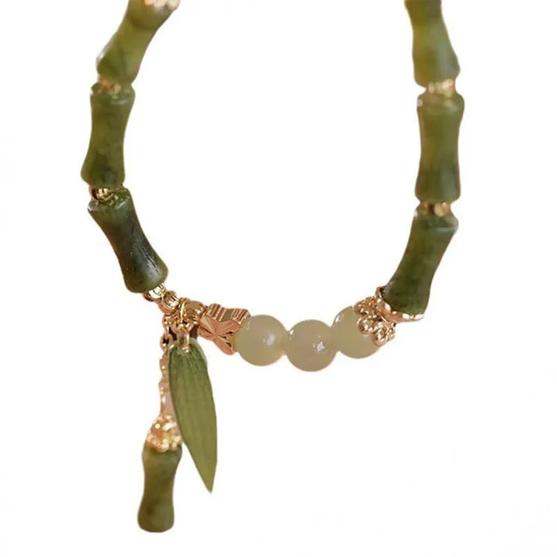 Chinese style handmade glass bead bracelet with bamboo joint elements on a white background.