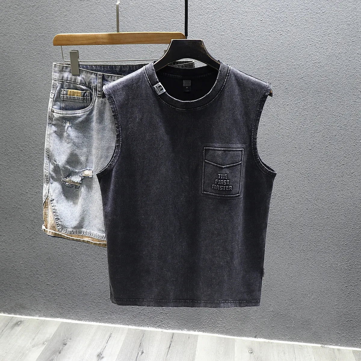 Men's solid black loose-fit cotton sleeveless t-shirt with a straight hem on a white background.