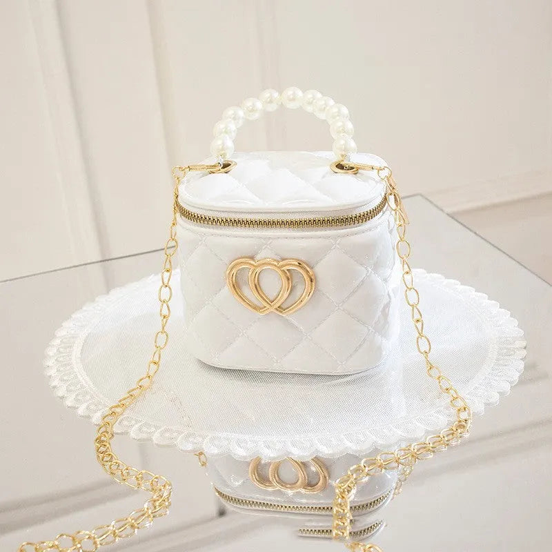White PVC bucket-shaped cosmetic bag with a red heart pattern, zipper open.