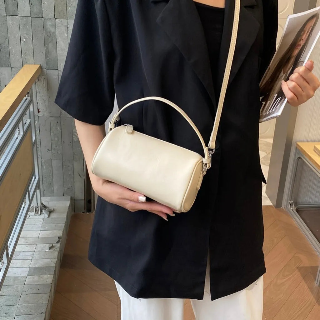 Genuine leather cylindrical crossbody bag for mobile phones in a street style, shown in brown.
